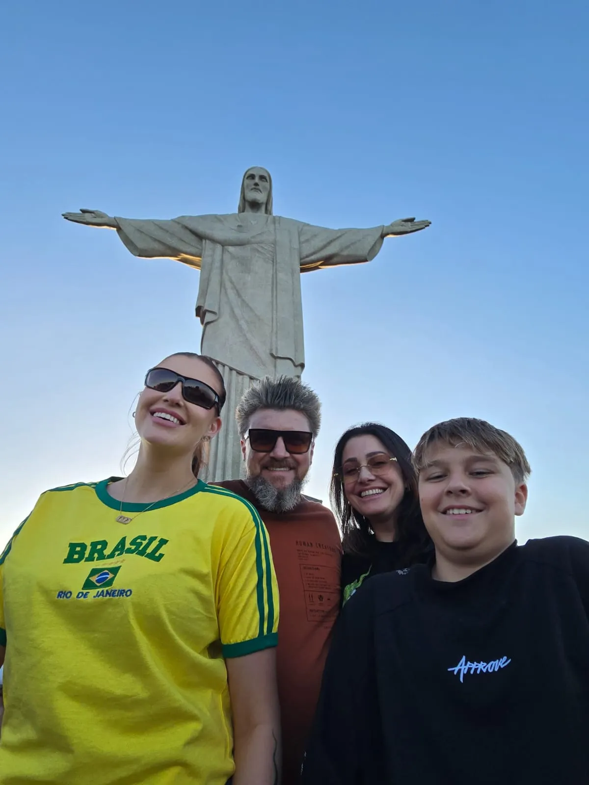 Four visitors beneath the Christ the Redeemer statue