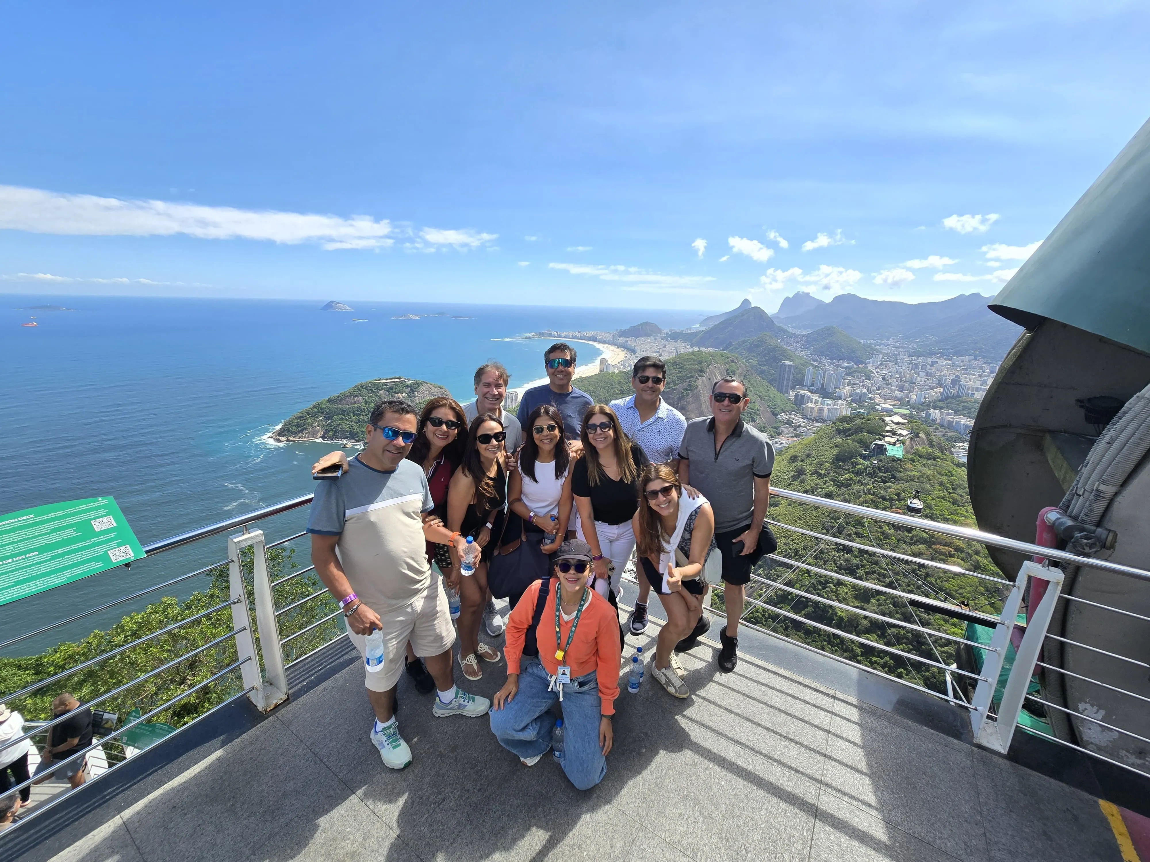 Visitors at an elevated viewpoint overlooking Rio’s coastline and mountains