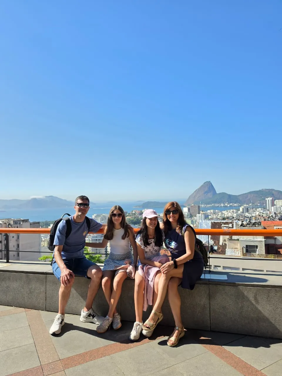 Visitors at a Rio viewpoint with Sugarloaf Mountain in the distance