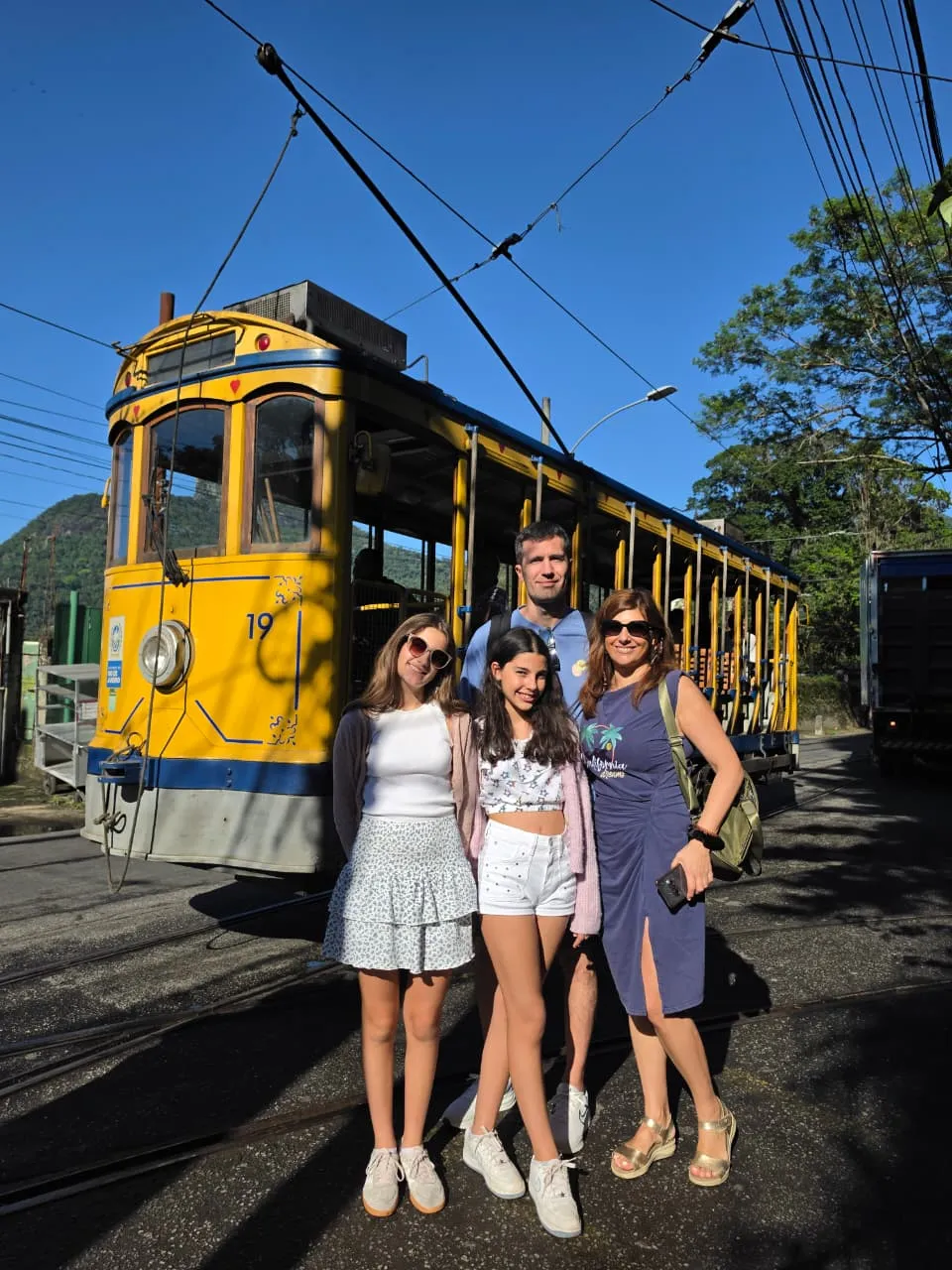 Visitors beside a yellow tram in Santa Teresa